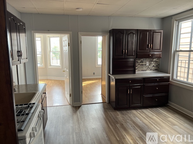 A kitchen with wooden cabinets and a stone backsplash is available.