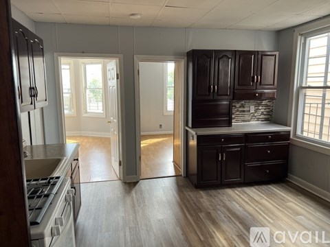 A kitchen with wooden cabinets and a stone backsplash is available.