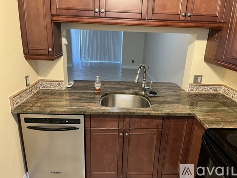 A kitchen with brown cabinets and a granite countertop.