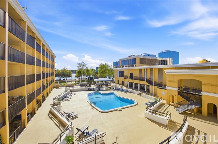A sunny day at the pool area of a hotel with a clear blue sky.