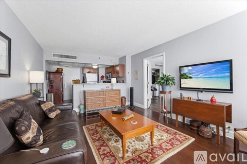 A living room with a brown leather couch and a wooden coffee table.