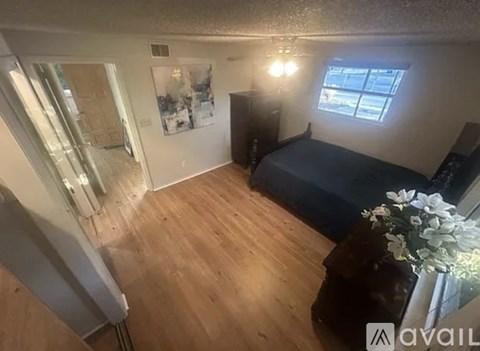 A bedroom with a bed, dresser, and window.