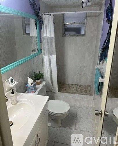 A bathroom with a toilet, sink, and shower.