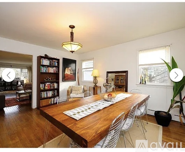 A dining room with a wooden table and chairs.