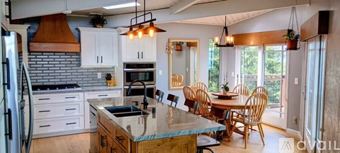 A kitchen with a table and chairs.