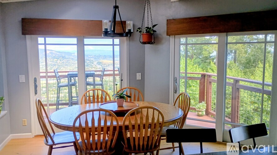 A dining room with a table and chairs and a view of the outdoors.