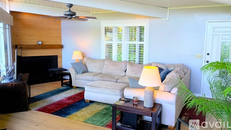 A living room with a couch, a coffee table, and a fireplace.