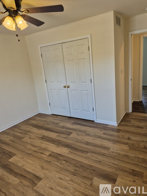 A room with a ceiling fan and a white door.