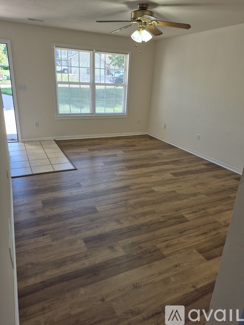 A room with wooden flooring and a ceiling fan.