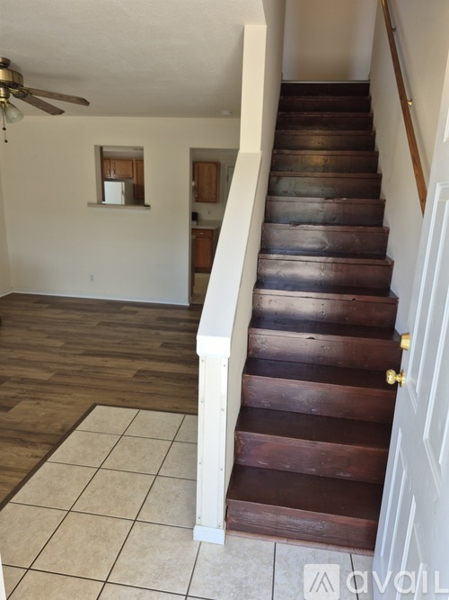 A staircase with a white railing and wooden steps.