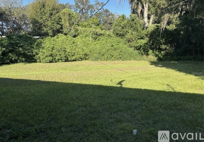 A grassy field with trees in the background.