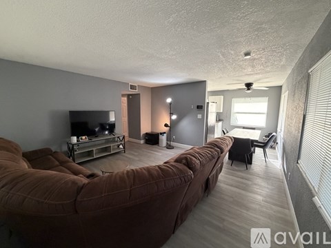 A living room with a brown couch and a television.