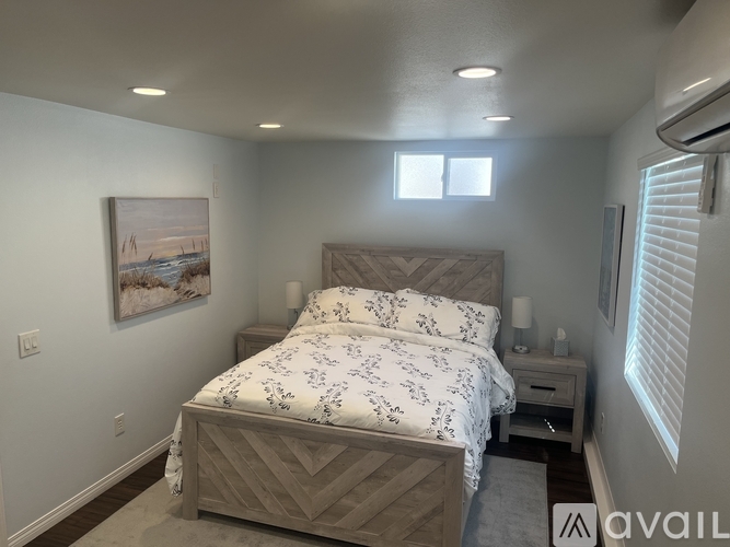 A bedroom with a large bed and a painting on the wall.