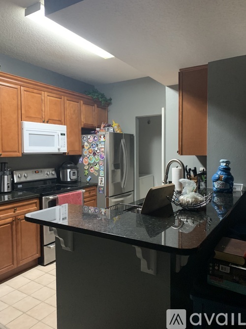 A kitchen with a black countertop and wooden cabinets.