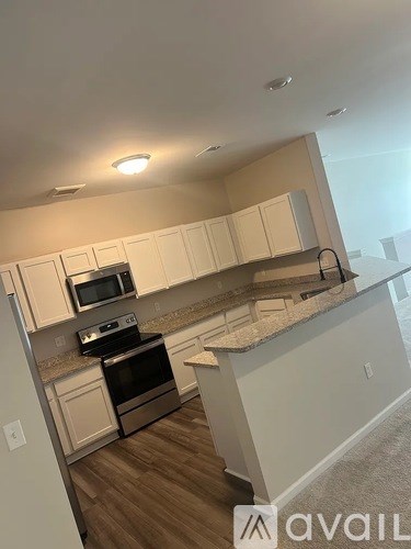 A kitchen with white cabinets and a stainless steel oven.