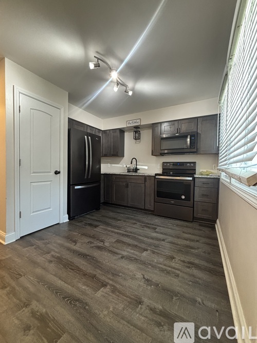 A kitchen with a white door and a black refrigerator.