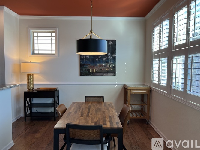A dining room with a wooden table and chairs.