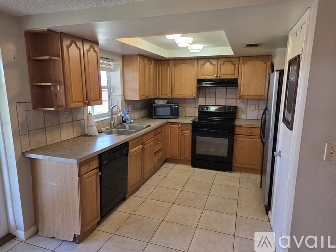A kitchen with wooden cabinets and black appliances.