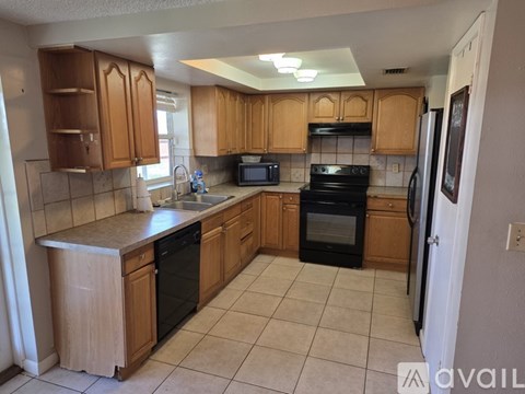 A kitchen with wooden cabinets and black appliances.