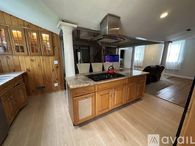 A kitchen with wooden cabinets and a marble countertop.