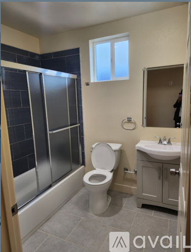 A bathroom with a toilet, sink, and shower.