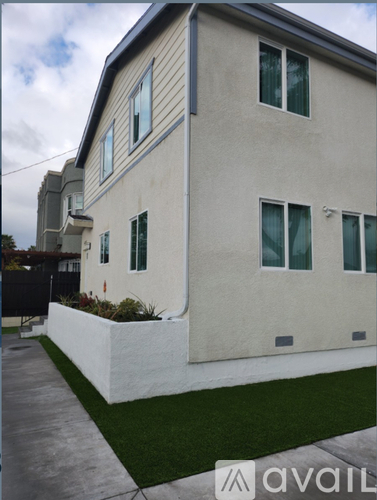 A modern house with a white exterior and a grey roof.