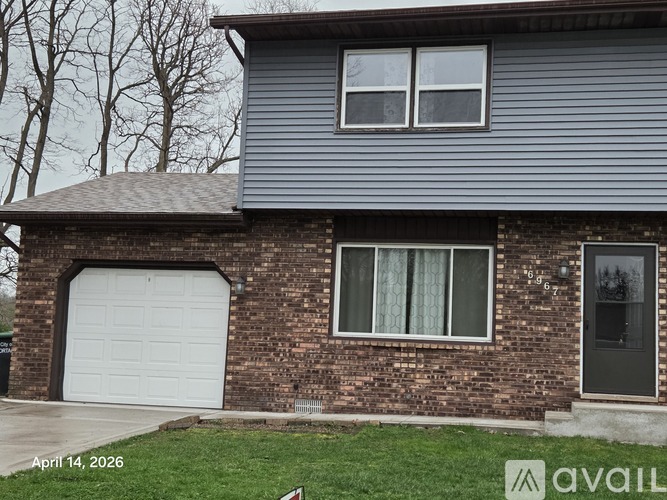 A house with a garage door and a brick wall.
