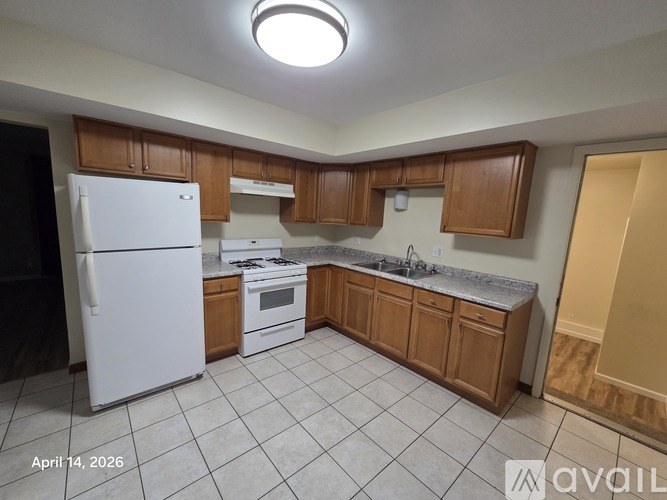 A kitchen with white appliances and wooden cabinets.