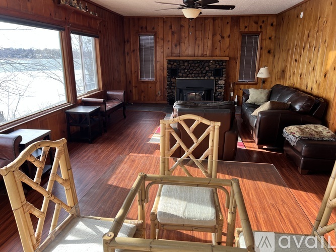 A wooden room with a fireplace and chairs.