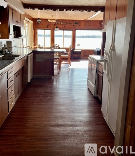 A kitchen with wooden floors and white appliances.