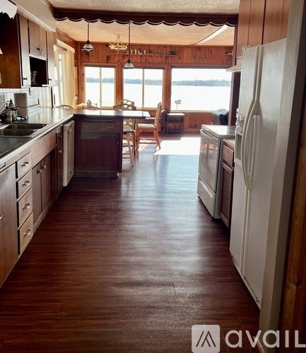 A kitchen with wooden floors and white appliances.