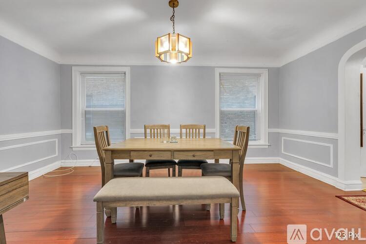 A dining room with a wooden table and chairs.