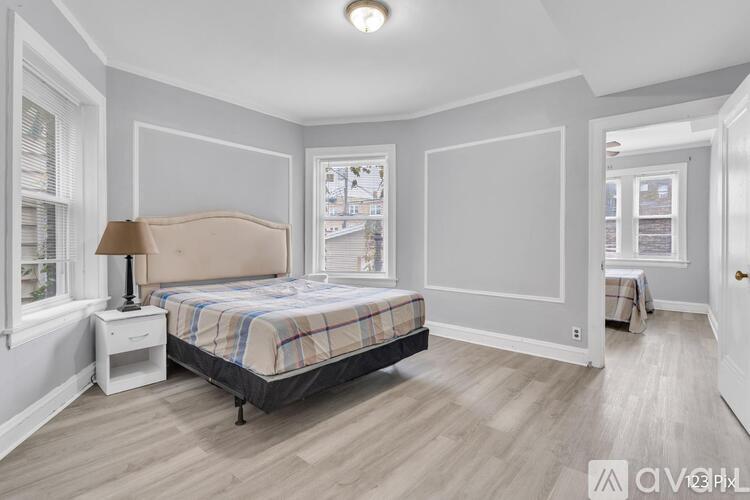 A bedroom with a bed, nightstand, and lamp.