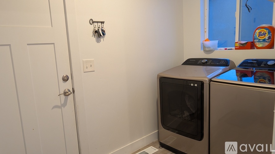 A kitchen with a white door, a white wall, and a microwave oven.
