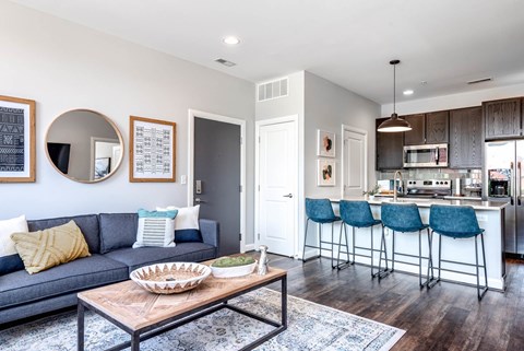 A modern living room with a grey sofa and a wooden coffee table.