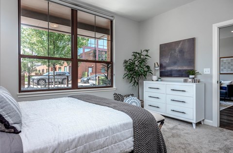 A bedroom with a large bed and a painting on the wall.