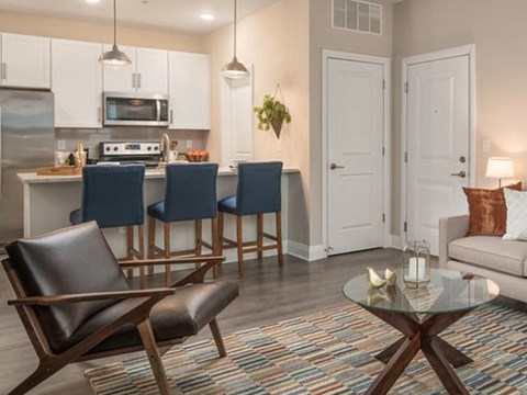 A modern kitchen with white cabinets and a glass table.