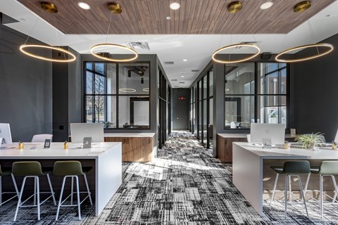 A modern office space with a long hallway, desks, and chairs.