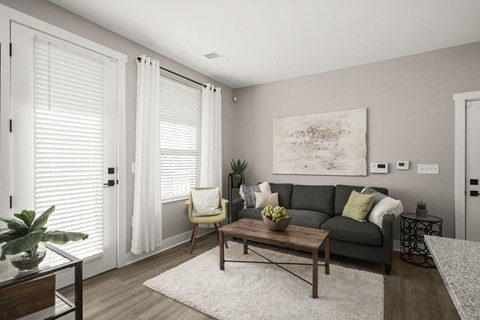 A living room with a grey couch, a coffee table, and a painting on the wall.