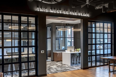 A modern office space with a glass wall and a sign that says "This must be the place".