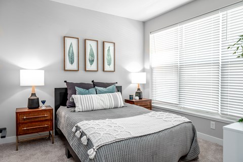 A bedroom with a large bed and two lamps.