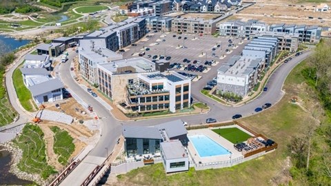 A large, modern building complex with a parking lot in front.