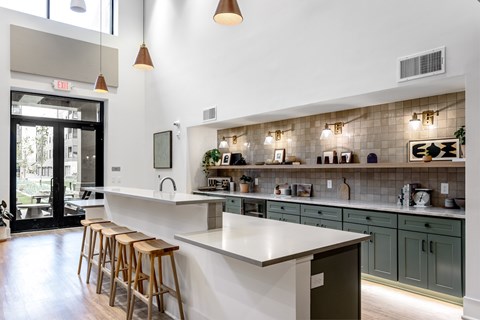 A kitchen with a white counter and wooden stools.