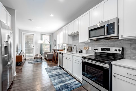 A modern kitchen with white cabinets and stainless steel appliances.