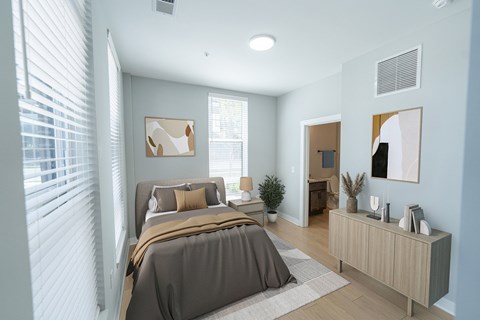 A bedroom with a large bed and a window with blinds.