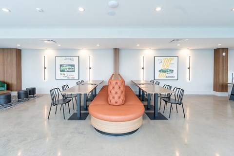 A modern dining room with a round orange bench in the center.