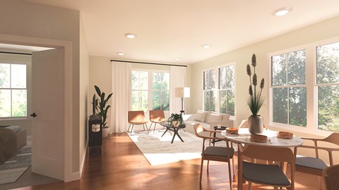 A modern living room with a dining table set up with chairs around it.