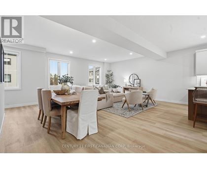 A spacious room with wooden flooring and white walls.