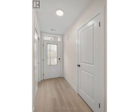 A hallway with white doors and a light on the ceiling.