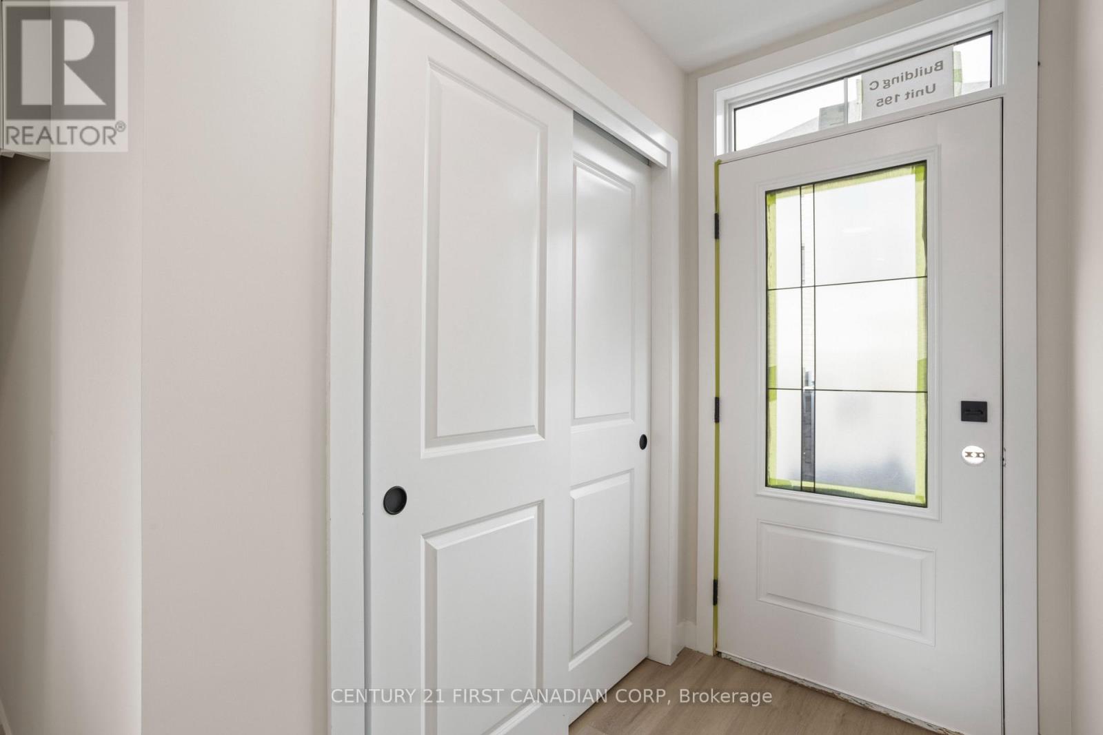 A white door with a window above it in a room.